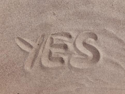 The word yes written in sand